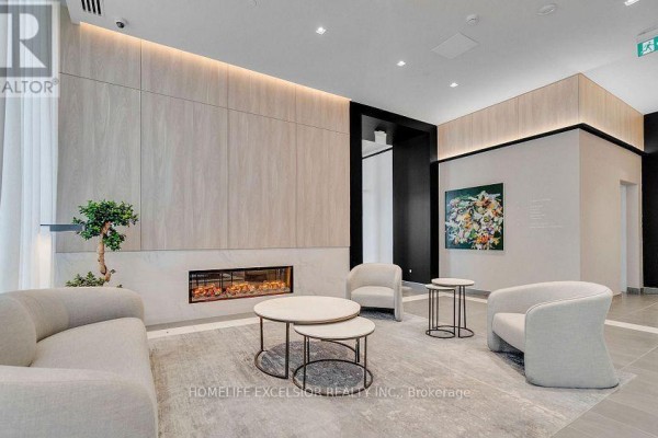 Building lobby lounge area with a linear fireplace, contemporary seating, and round tables. - 806 - 1 Jarvis Street, Hamilton