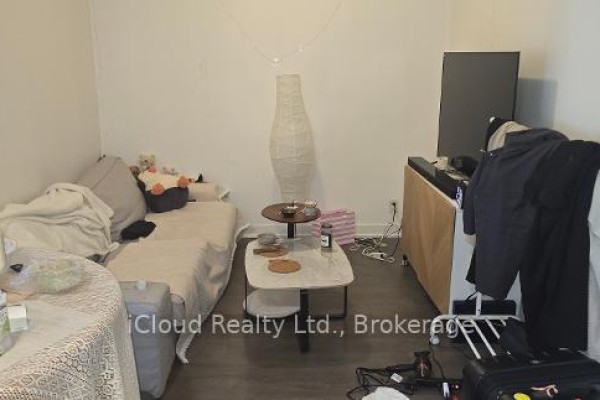 A bedroom with a sofa bed, coffee table, and a large lamp. - 806 - 28 Avondale Avenue, Toronto