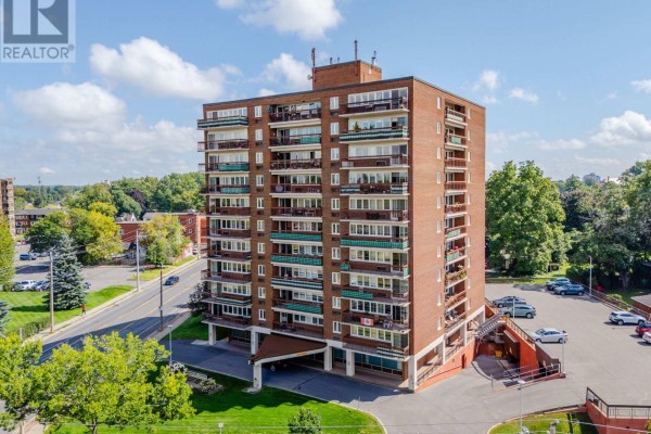 Aerial view of the brick apartment building with surrounding parking lot and green lawn. - 806 - 308 Second Street E, Cornwall