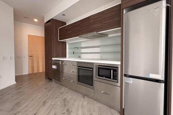 Kitchen area featuring dark wood cabinetry, stainless steel appliances, and a dishwasher. - 806 - 45 Charles Street E, Toronto