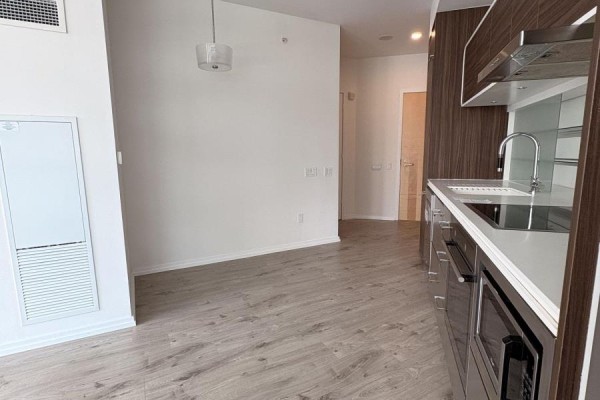Interior view of the kitchen area and hallway, with light wood flooring. - 806 - 45 Charles Street E, Toronto