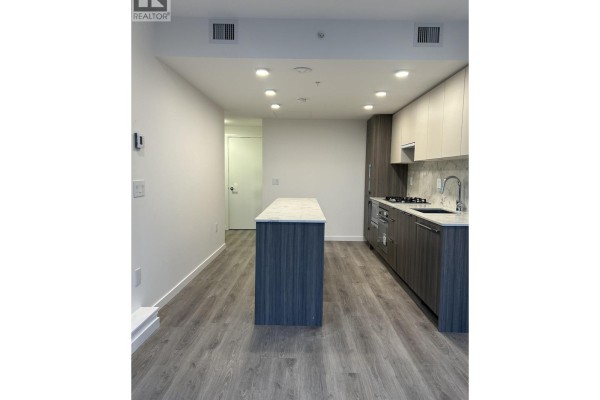 Kitchenette with dark wood lower cabinets, white upper cabinets, marble backsplash, and island. - 806 10333 133 Street, Surrey