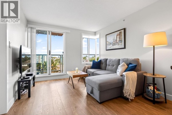 Living room with grey sectional sofa, television, coffee table, and balcony view. - 806 3455 Ascot Place, Vancouver