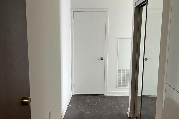 Hallway leading to doors and closet with dark wood accents - 806w - 27 Bathurst Street, Toronto