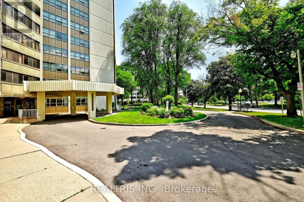 Driveway curves around landscaped garden in front of apartment building entrance. - 807 - 2323 Confederation Parkway, Mississauga