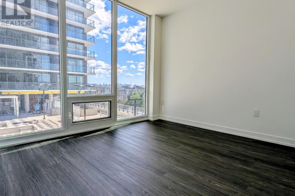 Apartment room with large corner windows showing a cityscape and cloudy sky. - 807 - 4010 Eglinton Avenue W, Toronto