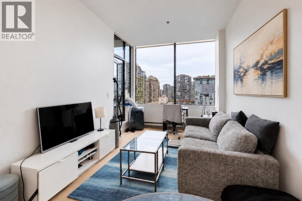 Spacious living room with grey sofa, large windows, and city skyline view. - 807 1010 Howe Street, Vancouver
