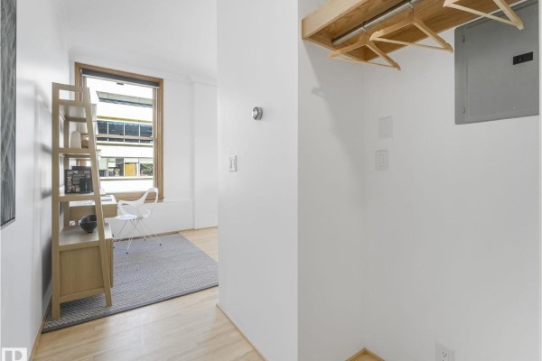 Hallway with open wood shelving, a desk with a chair, and a window. - #807 10134 100 St Nw, Edmonton