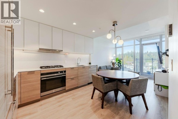 Kitchen with island, dining table, and living area visible in background. - 808 1045 Austin Avenue, Coquitlam