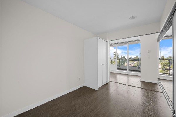 View from balcony of trees, landscaping, and adjacent apartment buildings. - 808 13303 Central Avenue, Surrey