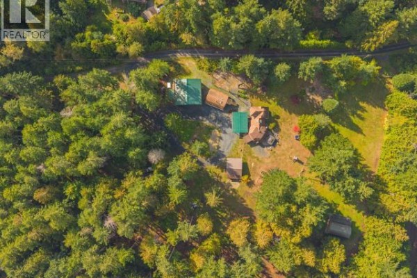 Overhead aerial view of the residential property nestled among trees. - 8089 Daisy Road, Powell River