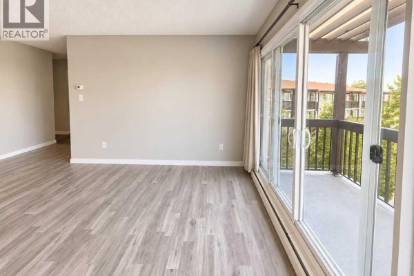 Wide aerial view of the apartment buildings, parking lots, and tree-lined neighborhood. - 809, 8948 Elbow Drive Sw, Calgary