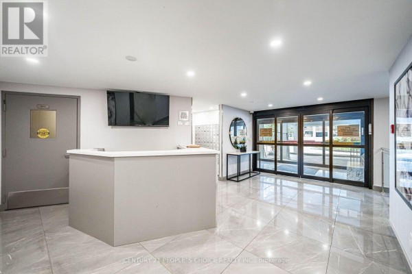 The building's lobby features a reception desk, mailboxes, and polished tiled floors. - 809 - 10 Edgecliffe Golfway, Toronto