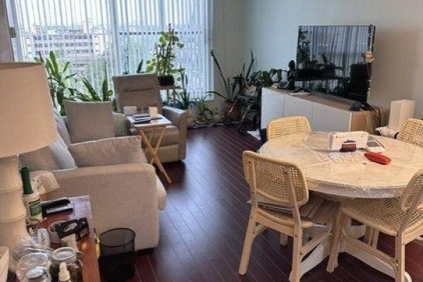 Living and dining area with sofa, recliner, round table, and television. - 809 - 2 Neptune Drive, Toronto