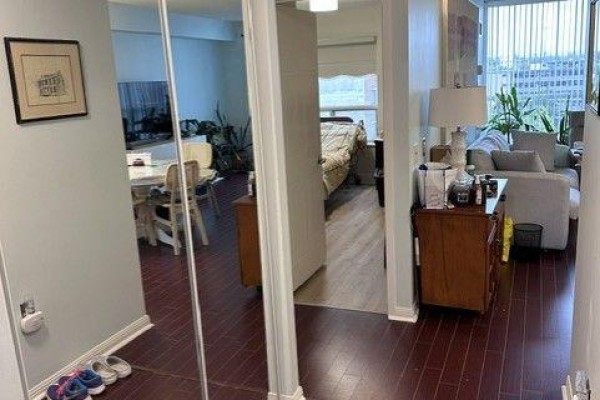 Hallway view with mirrored closet doors, reflection of dining area and living room. - 809 - 2 Neptune Drive, Toronto