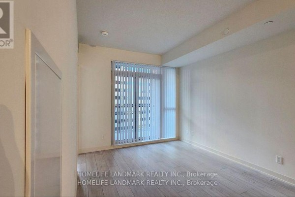 Corner view of an empty room with light wood floors and floor-to-ceiling windows. - 809 - 4955 Yonge Street, Toronto
