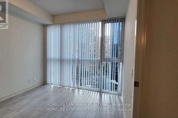 Light wood floor room with large windows and vertical blinds overlooking a city view. - 809 - 4955 Yonge Street, Toronto