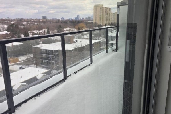 Balcony with glass railings and metal frame covered in snow, overlooking a residential neighborhood. - 809 - 556 Marlee Avenue, Toronto