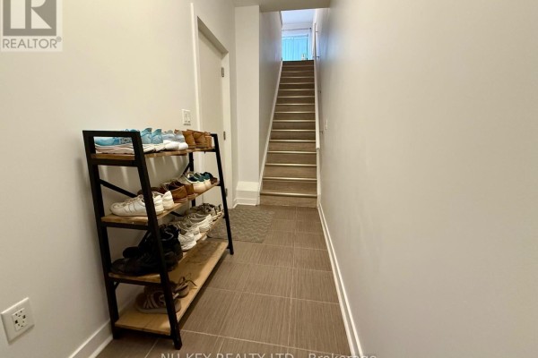 Hallway with tiled floor, shoe rack, and staircase leading upwards. - 81 - 369 Essa Road, Barrie