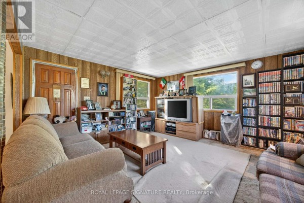Bedroom with a queen-size bed, white paneled walls, and a window with blinds. - 81-77 Bass Bay Drive, Tay