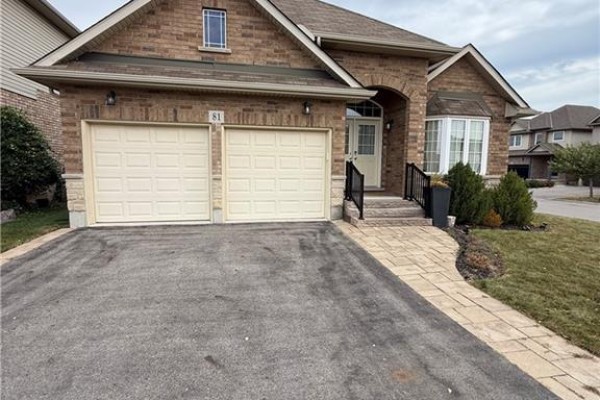 Close-up of the brick house exterior, double garage doors, and front entrance. - 81 Bellagio Avenue, Hamilton