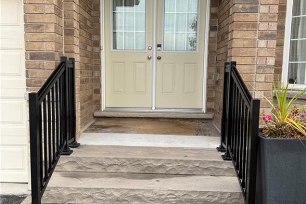 Concrete front steps with textured stone risers and black metal railings. - 81 Bellagio Avenue, Hamilton