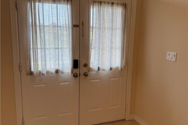 Interior view of double doors with sheer beige curtains and a light switch. - 81 Bellagio Avenue, Hamilton