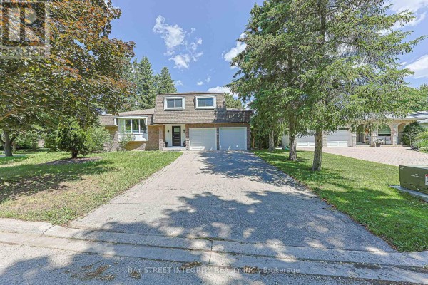 Wide view of the driveway and front exterior of a residential house with mature trees. - 81 Dawn Hill Trail, Markham