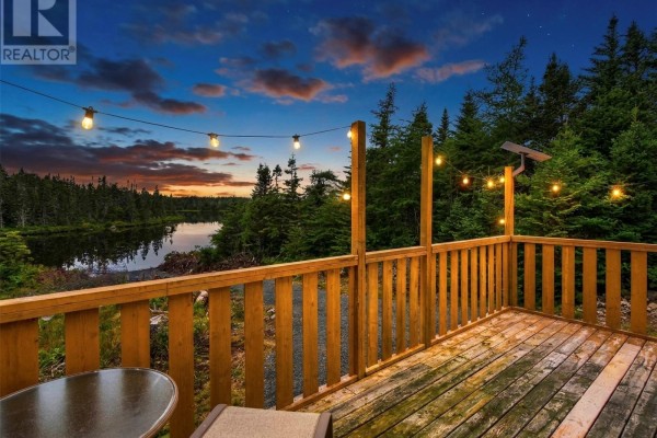 View from the wooden deck overlooking a calm lake surrounded by dark green pine trees. - 81 Strayaway Road, Blaketown