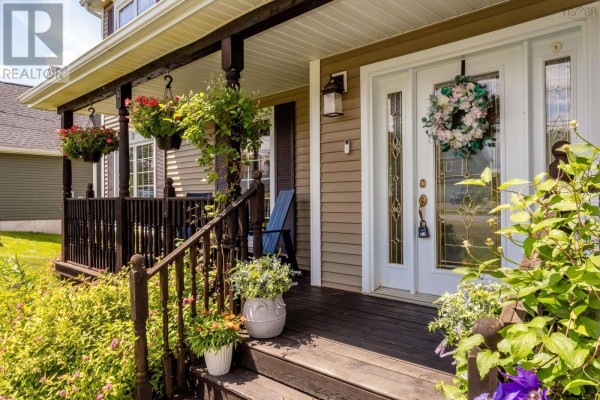 Close-up of the front door with double sidelights, a wreath, and porch seating. - 81 Terra Nova Drive, Greenwood