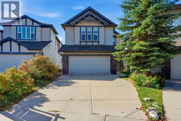 Front exterior of a two-story suburban house with a beige siding and dark trim. - 81 Walden Rise Se, Calgary