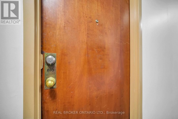 Close-up of apartment door 810 with brass knob and lock on a wooden door. - 810 - 10 Tapscott Road, Toronto
