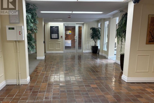 Building lobby with checkered tiled floor and potted plants. - 811 - 1356 Meadowlands Drive E, Ottawa