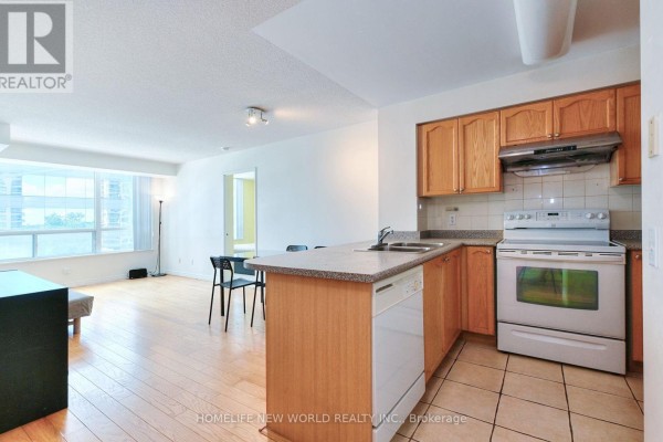 Open-concept living area and kitchen with light wood cabinets, white appliances, and light wood floors. - 811 - 18 Parkview Avenue, Toronto