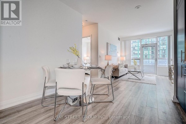 Kitchen with dark wood cabinets, granite countertops, stainless steel appliances, and coffee maker. - 811 - 2 Anndale Drive, Toronto