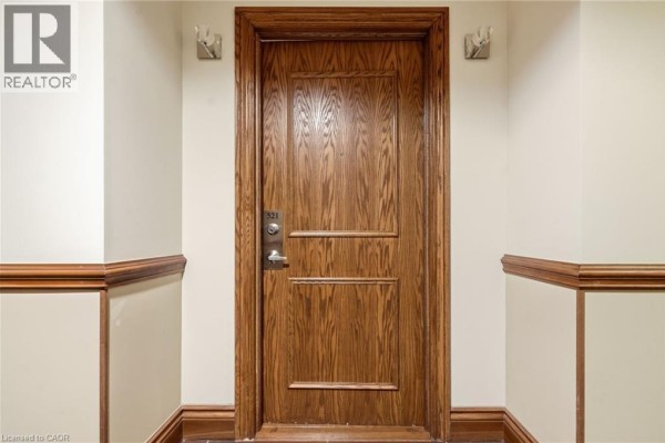 Close-up of a closed wooden apartment door with a silver handle and the number 521. - 8111 Forest Glen Drive Unit# 521, Niagara Falls