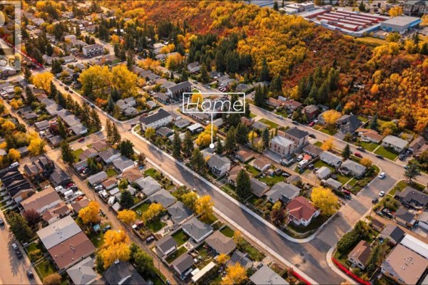 Aerial view of a residential neighborhood with homes and mature trees in autumn colors. - 8119 34 Avenue Nw, Calgary