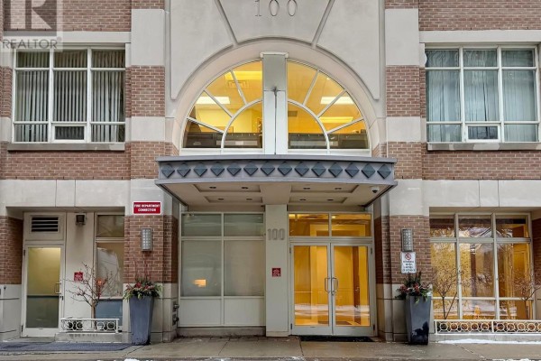 Main entrance of 100 Hayden Street building with glass doors and arched window above. - 812 - 100 Hayden Street, Toronto