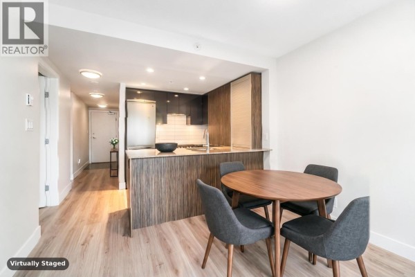 Dining area with round table and four grey chairs next to the kitchen counter. - 813 1088 Richards Street, Vancouver