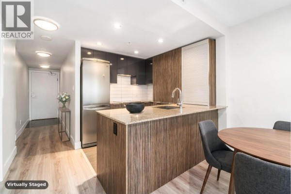 Kitchen with stainless steel appliances, granite countertop, and wood-grain cabinetry. - 813 1088 Richards Street, Vancouver