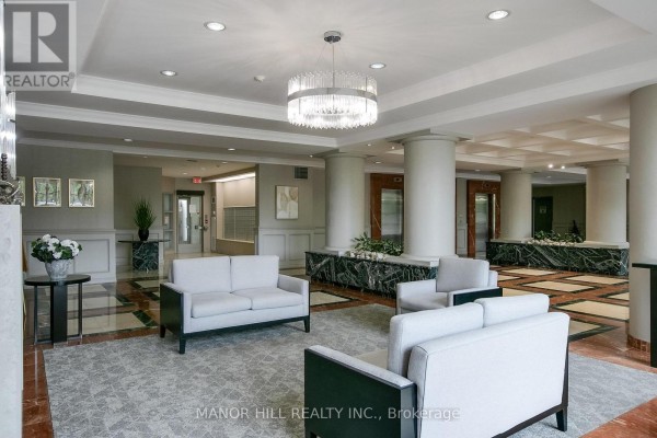 Apartment building lobby with white sofas, chairs, marble accents, and elevators. - 814 - 11 Townsgate Drive, Vaughan