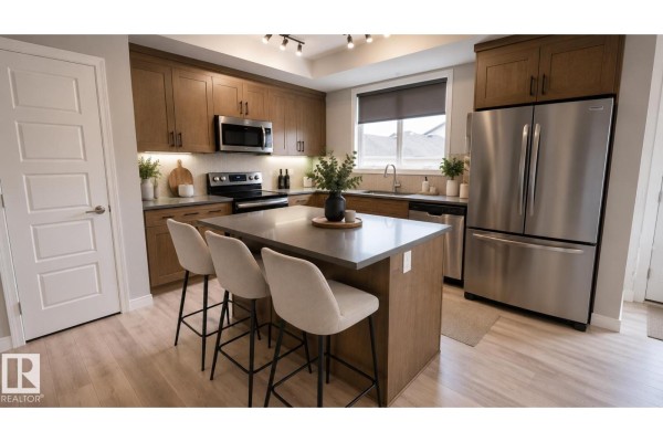 Kitchen with wood cabinets, stainless steel appliances, a central island with seating, and a window. - 8145 Chappelle Wy Sw, Edmonton