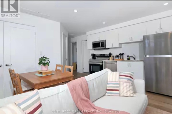 Modern kitchen with white cabinets, stainless steel appliances including a dishwasher, oven, and refrigerator. - 815 - 4263 Fourth Avenue, Niagara Falls