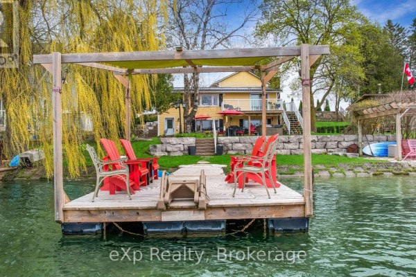 Floating dock with red chairs and a wooden canopy on the water. - 816 Marl Lake Road 8, Brockton