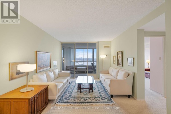 Another angle of the living room showcasing white sofas, decorative rug, and wall art. - 817 - 25 Austin Drive, Markham