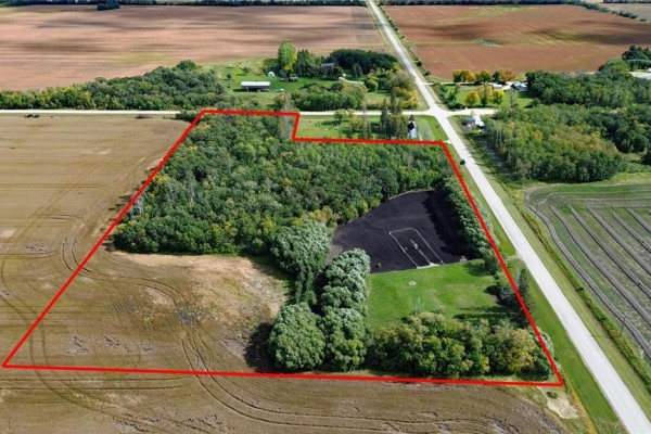 Aerial view showing property boundary, trees, field, and small white building. - 817 Cloverdale Road, St Andrews