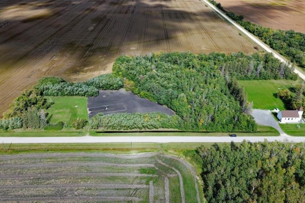 Drone shot of property showing land outline, trees, cleared area, and nearby church. - 817 Cloverdale Road, St Andrews