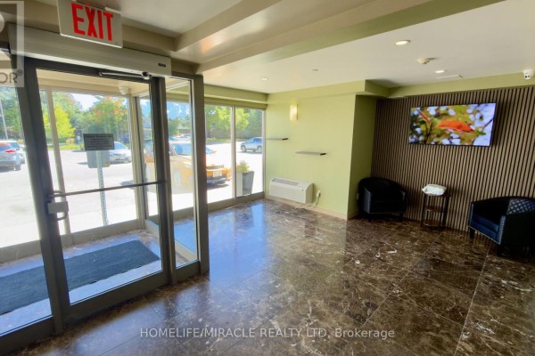 Building lobby with glass doors, marble floors, seating area, and decorative wall. - 818 - 239 Auburn Drive, Waterloo