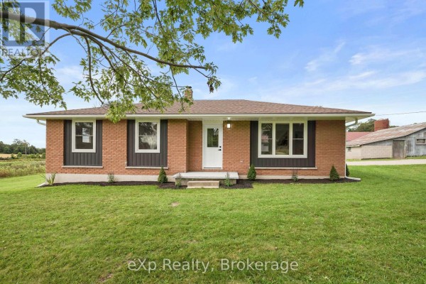 Exterior of a brick house with multiple windows and a small concrete porch. - 81827 Baseline Road, Central Huron