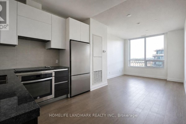 Kitchen with stainless steel appliances, black granite countertops, and view of living room and window. - 819 - 15 Water Walk Drive, Markham